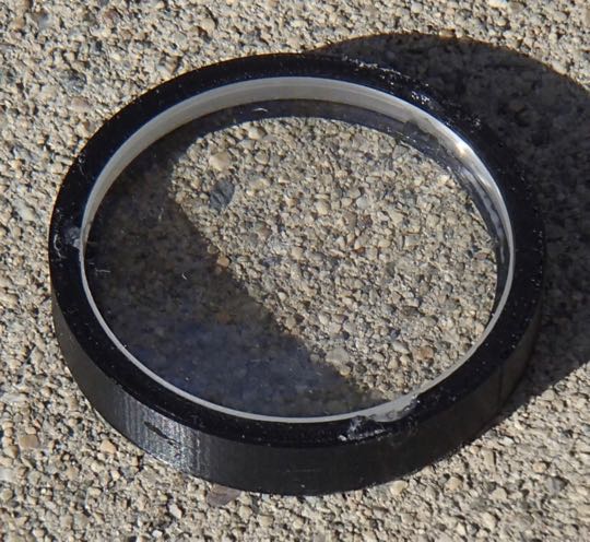 <strong>Objective lens in 3D printed holder. FL=360 mm. Dia=50.8 mm. The lens is actually two lenses, one of "flint" glass and one of "crown" glass in order to eliminate chromatic aberration. I used three small blobs of silicone glue to hold the lenses in the lens holder.</strong>